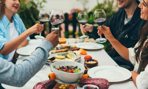 a group of people having a meal around an outdoor table