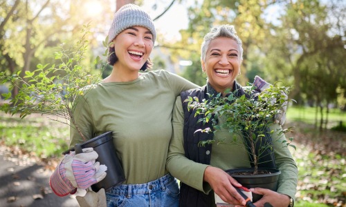 a couple of women holding plants